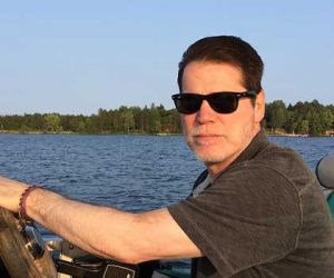 Bob Ohly, Partner and CFO at Caffe Ladro/Ladro Roasting driving a pontoon in Minnesota