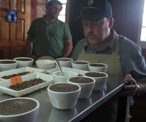 Jack Kelly, head coffee buyer for Ladro Roasting, prepares to score a table full of coffee samples using the coffee cupping method