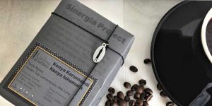 sinergia project from ladro roasting with coffee beans and a black caffe ladro coffee cup and saucer